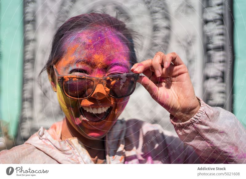 Positive Frau mit Gesicht in Holi-Pulver heiter Stadtfest hinduistisch Straße feiern farbenfroh Spaß haben Farbe Indien Veranstaltung sonnig Tradition Kultur