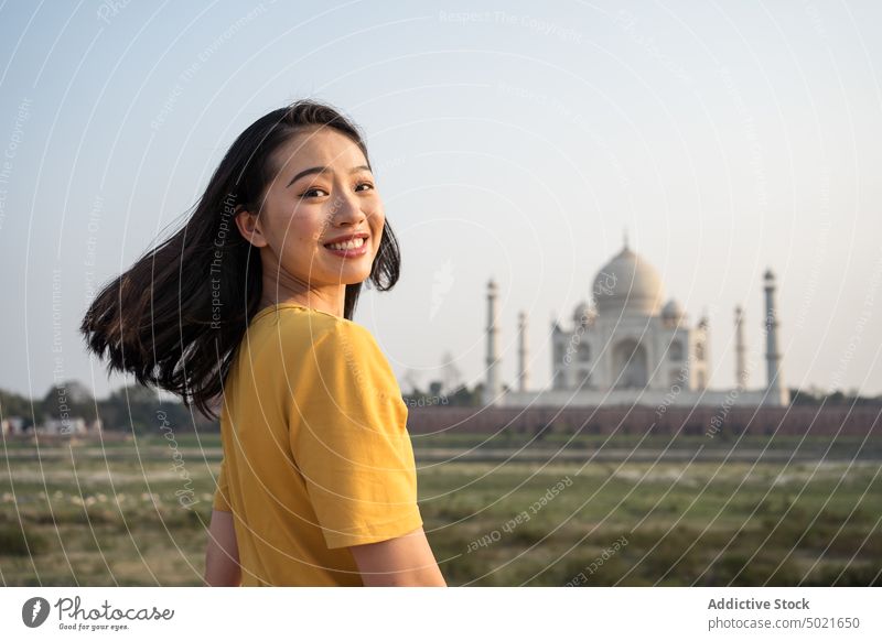 Lächelnde reisende Frau in der Nähe des Taj Mahal Tourist Sightseeing historisch Wahrzeichen Mausoleum Urlaub asiatisch ethnisch Agra Indien Tourismus Ausflug