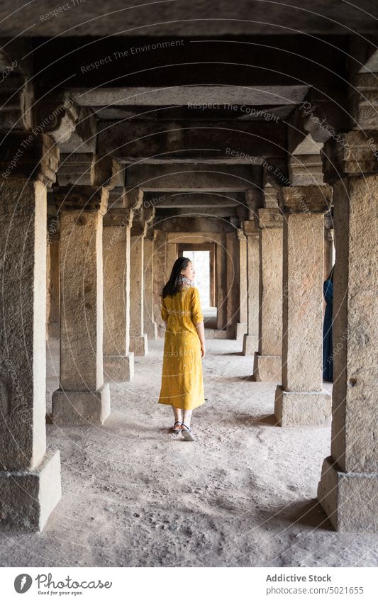 Weiblicher Reisender, der in ein Steingebäude geht Frau alt Gebäude Spalte Spaziergang Dorf erkunden Tourist Hauz Khas Neu Delhi Indien Wand Architektur reisen