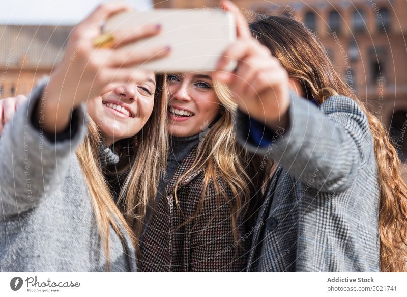 Gesellschaft von Frauen nehmen Selfie entlang Platz in der Stadt Quadrat Smartphone Zusammensein Großstadt Stil Freundschaft sorgenfrei benutzend Handy