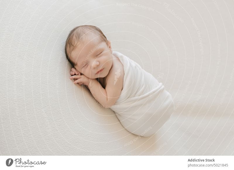 Niedliches Kleinkind in Decke eingewickelt Baby umhüllen schlafen Säugling weich Angebot unschuldig niedlich wenig Kind Lügen Kindheit bezaubernd friedlich