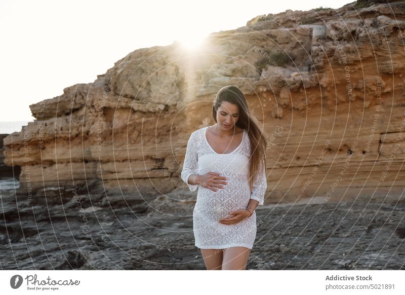 Schwangere Frau in der Nähe einer Sandsteinklippe Klippe Sommer Natur schwanger berühren Bauch erwarten mütterlich vorwegnehmen pränatal sanft Schwangerschaft