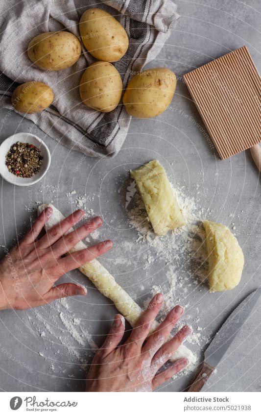 Person, die Kartoffelteig für Nudeln ausrollt rollen Teigwaren Spätzle Koch Gnocchi Tisch Küche Paprika Mehl vorbereiten Lebensmittel Bestandteil Prozess frisch
