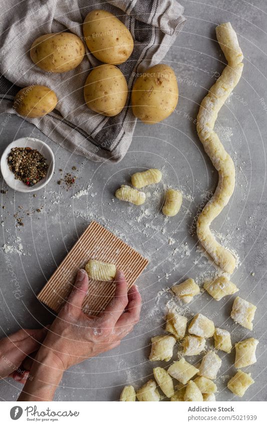Erntehelfer kocht Kartoffelgnocchi für das Mittagessen Person Teigwaren Gnocchi Presse Holzplatte gerippt Spätzle Koch Tisch Küche Paprika Mehl vorbereiten