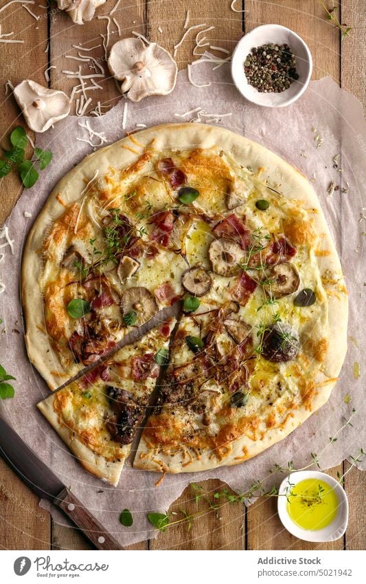 Draufsicht auf eine leckere Pizza mit Basilikum und Tomatensauce auf einem Holztisch in der Nähe einer Serviette in der Küche geschmackvoll Pilz Lebensmittel