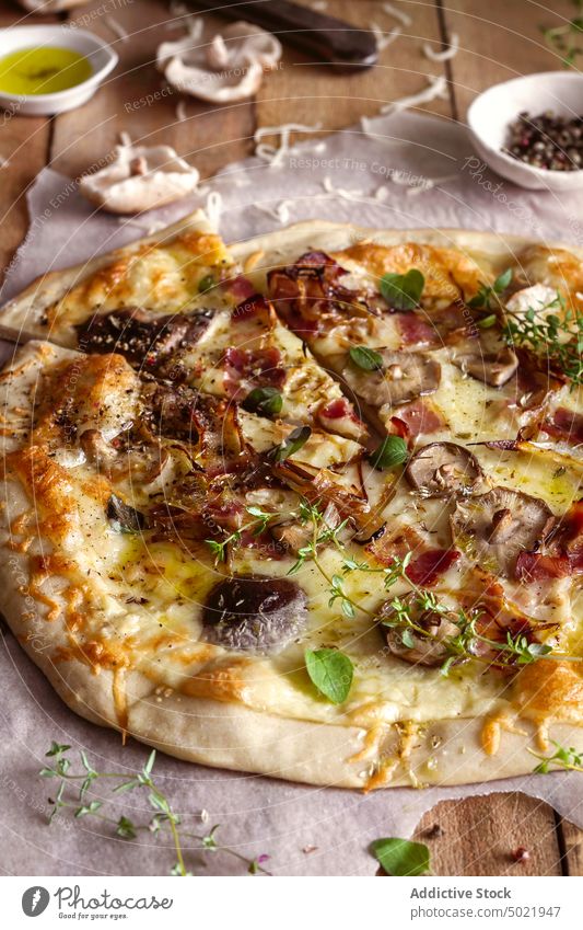Draufsicht auf eine leckere Pizza mit Basilikum und Tomatensauce auf einem Holztisch in der Nähe einer Serviette in der Küche geschmackvoll Pilz Lebensmittel