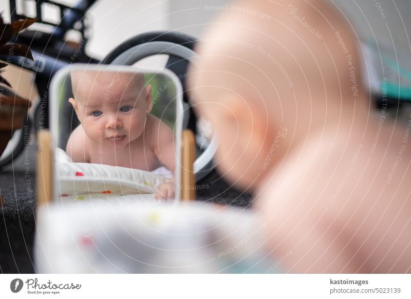 Schöne Aufnahme eines süßen kleinen Jungen, der sein Spiegelbild betrachtet. Baby Kind Porträt spielen Reflexion & Spiegelung Säugling Kindheit niedlich schön
