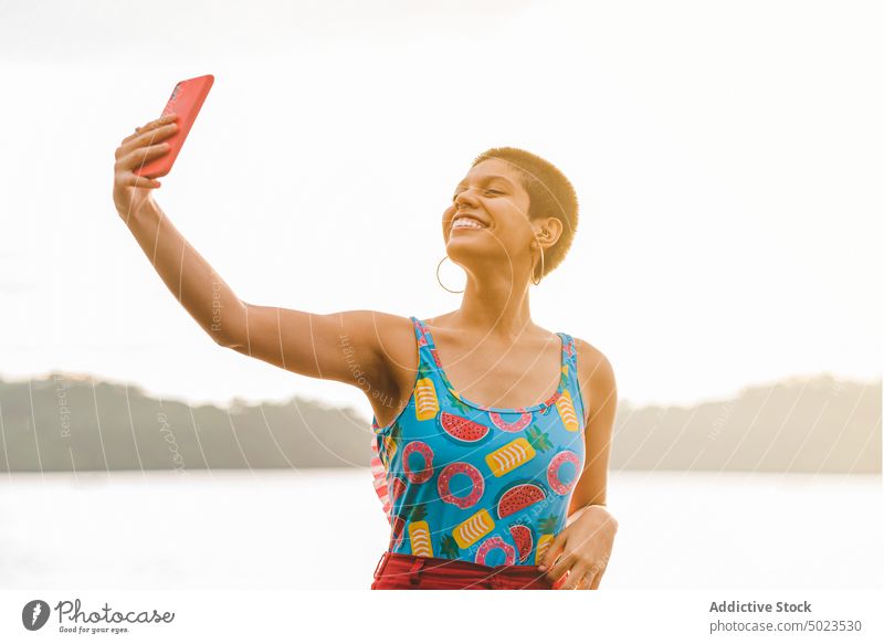 Glückliche Frau nimmt Selfie am Strand Sommer Smartphone heiter Lächeln Urlaub sorgenfrei farbenfroh jung tausendjährig genießen Apparatur Mobile benutzend