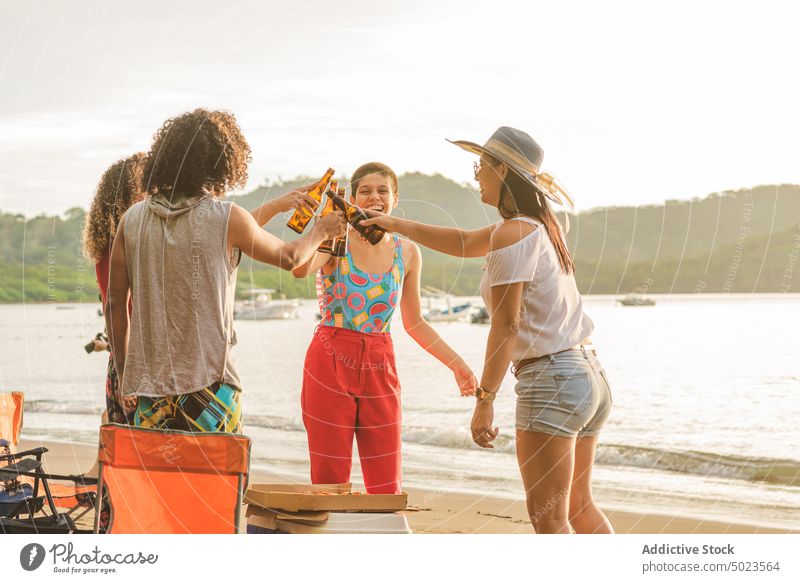 Fröhliche Freunde stoßen am Strand mit Bierflaschen an Klirren Flasche heiter Sommer sich[Akk] sammeln Treffpunkt Zusammensein Glück Menschengruppe jung trinken