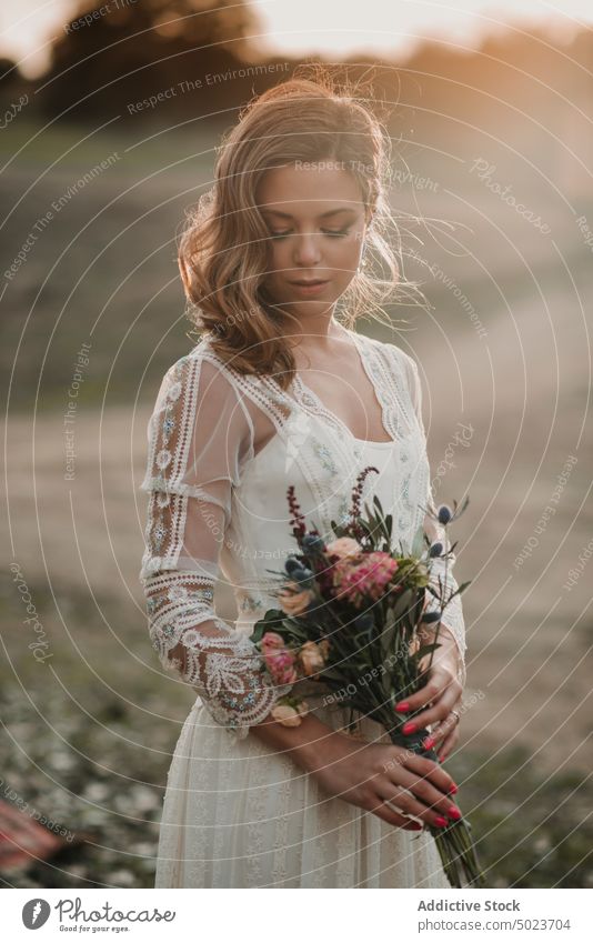 Charmante Frau im Kleid mit Blumenstrauß auf einem Feld Hochzeit Dame Hand Behaarung Haufen Wiese sonnig jung attraktiv charmant leidenschaftlich Heirat Party