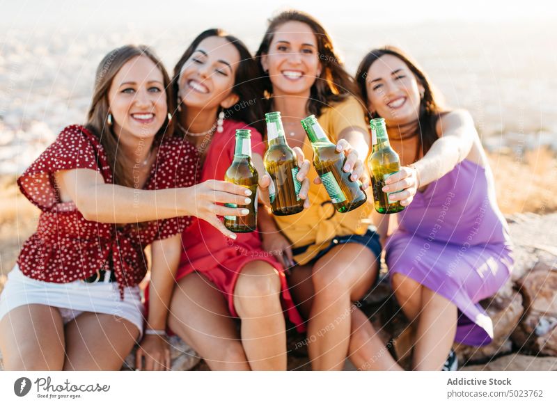 Glückliche Freunde stoßen mit Bierflaschen an Frauen Klirren Zuprosten Freude Freundin Spaß jubelt Flasche Menschengruppe sich[Akk] sammeln trinken Alkohol