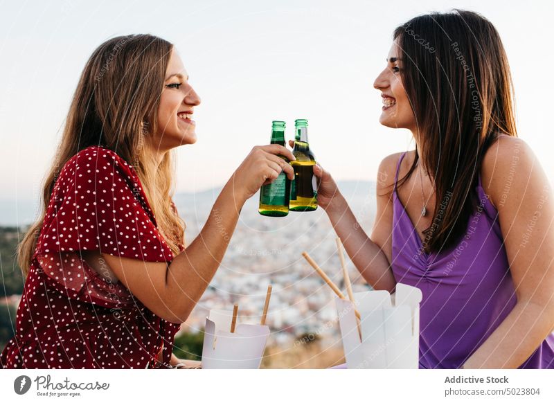 Glückliche Freunde stoßen mit Flaschen an und trinken Bier Frauen sich[Akk] sammeln Klirren Natur Küste Alkohol heiter Getränk Stein Borte Glas Zusammensein