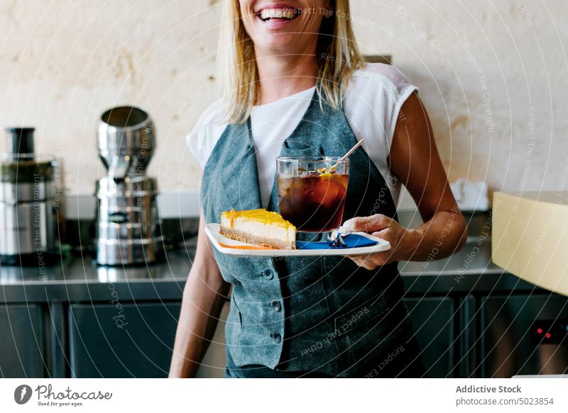 Frau trägt vorsichtig ein Stück gelben Kuchen süß Pasteten Gebäck Café Verkäufer Lebensmittel Dessert Bäckerei frisch geschmackvoll Restaurant Kantine Beruf