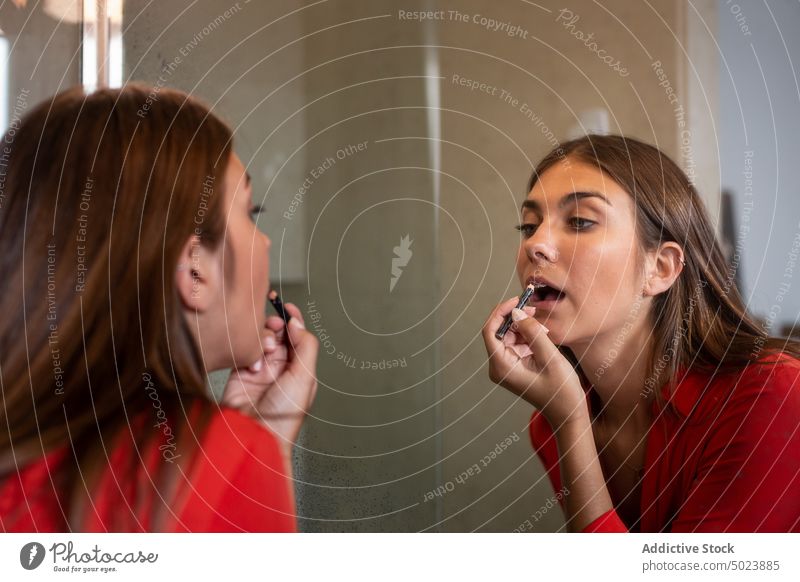 Junge Frau trägt zu Hause Lipliner auf Make-up Spiegel heimwärts lässig Lippe Bleistift Liner Kosmetik trendy Glamour Mode Schönheit Pflege Stil Werkzeug modern