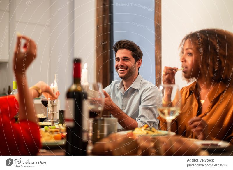 Multiethnische Freunde genießen das Abendessen zu Hause Zusammensein heimwärts Party feiern Speise festlich Veranstaltung sich[Akk] sammeln Mahlzeit Feiertag