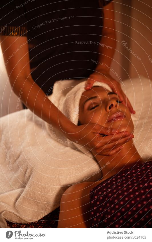 Anonyme Masseurin bei der Gesichtsmassage einer jungen Frau massierend Thaimassage Behandlung Massage Therapie asiatisch Spa Körper Wellness Pflege Schönheit