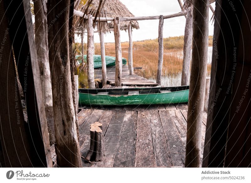Schäbiges Boot auf einem Holzsteg im Dorf Pier Landschaft Fluss Kai schäbig hölzern alt rustikal ländlich Wasser verwittert Nutzholz Gefäße Sommer gealtert