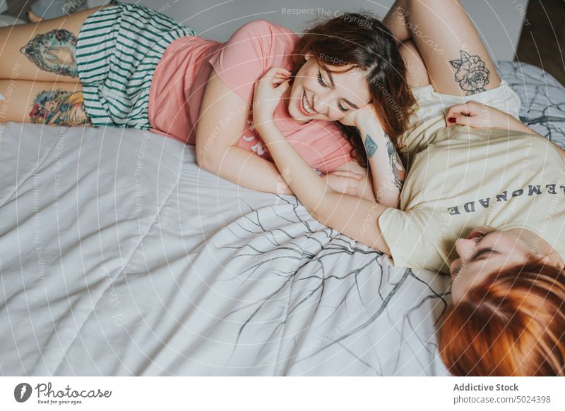 Frauen mit Tattoos auf dem Bett liegend Schlafzimmer im Innenbereich Kopfkissen Komfort Freizeit alternativ anonym Kunst Streu Paar gemütlich Ernte gesichtslos