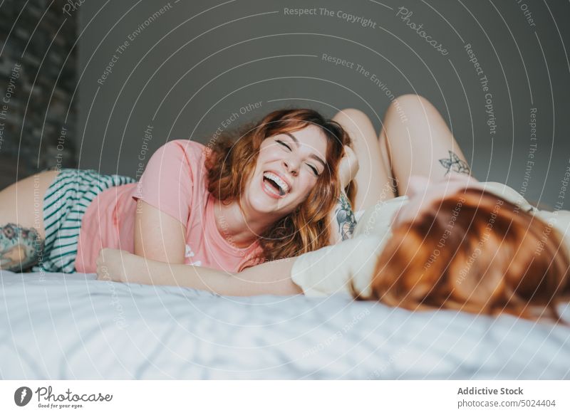 Frauen mit Tattoos auf dem Bett liegend Schlafzimmer im Innenbereich Kopfkissen alternativ anonym Kunst Streu Komfort Paar gemütlich Ernte gesichtslos Freund