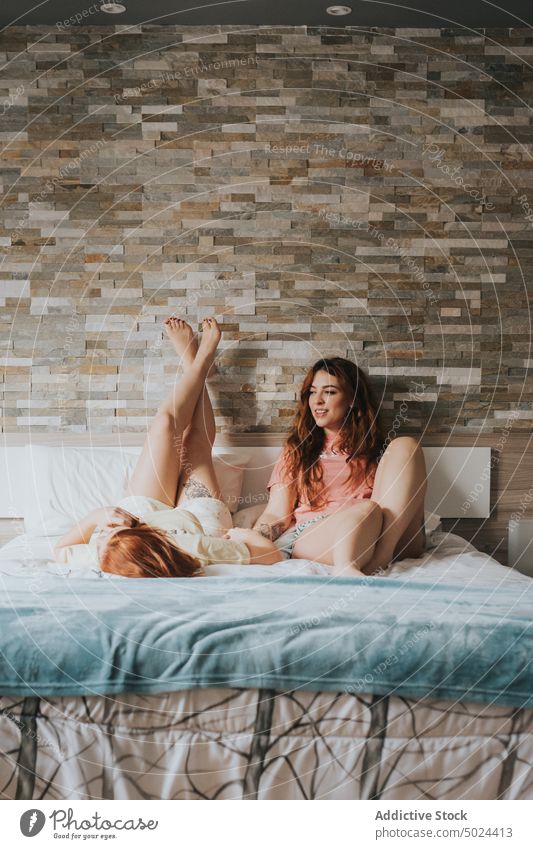 Frauen mit Tattoos auf dem Bett liegend Schlafzimmer im Innenbereich Freizeit heimwärts alternativ anonym Kunst Streu Komfort Paar gemütlich gesichtslos Freund