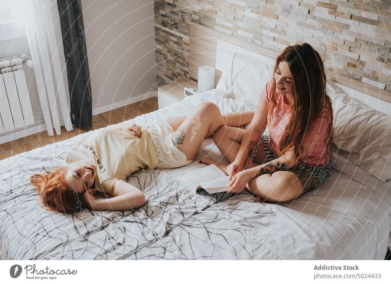 Frauen mit Tattoos auf dem Bett liegend Schlafzimmer im Innenbereich Kopfkissen Freizeit alternativ Kunst Streu Komfort Paar gemütlich Freund Freundschaft Spaß