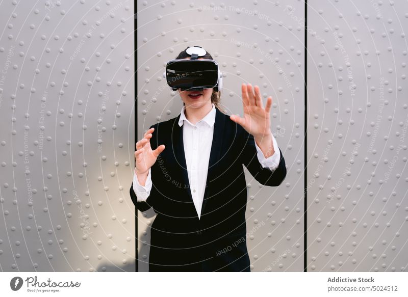 Geschäftsfrau mit VR-Brille in der Stadt Virtuelle Realität Schutzbrille Erfahrung Großstadt Unternehmer virtuell Frau Straße unterhalten Cyberspace Gerät