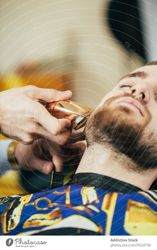Friseur in einem Friseursalon Vollbart Schönheit Pflege Klient Schermaschine geschnitten elegant Behaarung Haarschnitt Hände Kopf im Innenbereich Lifestyle
