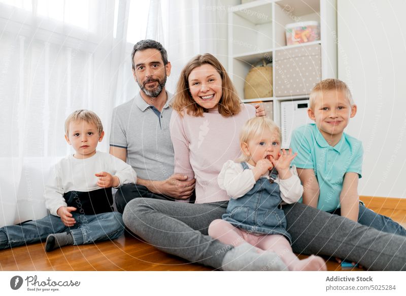Fröhliche Familie klatscht zu Hause auf dem Boden in die Hände Kinder Klatschen Spaß haben heiter Kindheit Wochenende Elternschaft Porträt Parkett