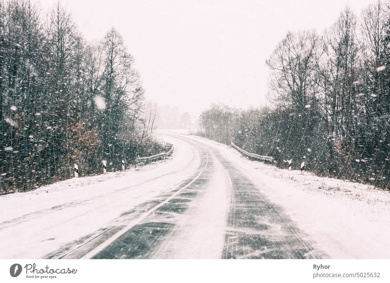 Schneebedeckte Straße während eines Schneesturms. Ungünstige Wetterbedingungen Verkehr Natur Sicherheit gefroren kalt Gefahr Voraussetzung Asphalt Saison