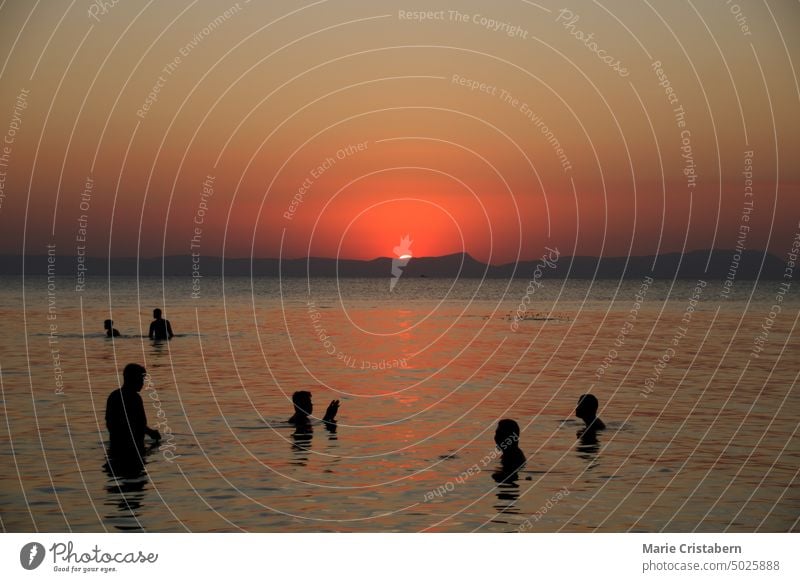 Silhouetten von Menschen genießen das warme Meer während des Sonnenuntergangs in Koh Tonsay oder Rabbit Island in Kambodscha Lifestyle Menschen Silhouetten