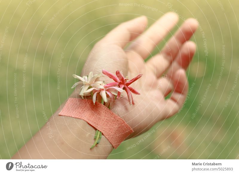 Konzeptfoto von Blumen, die auf ein Handgelenk geklebt wurden, um das Bewusstsein für Selbstmord, psychische Gesundheit und Wellness zu zeigen