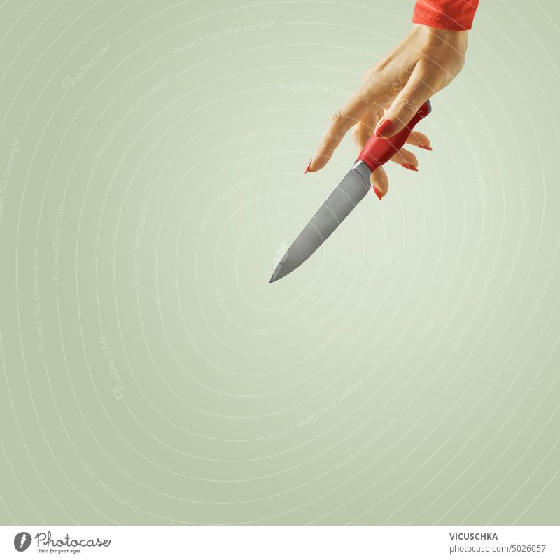 Frauenhand mit Küchenmesser auf grünem Hintergrund Hand Messer rot Objekt Menschen Werkzeug