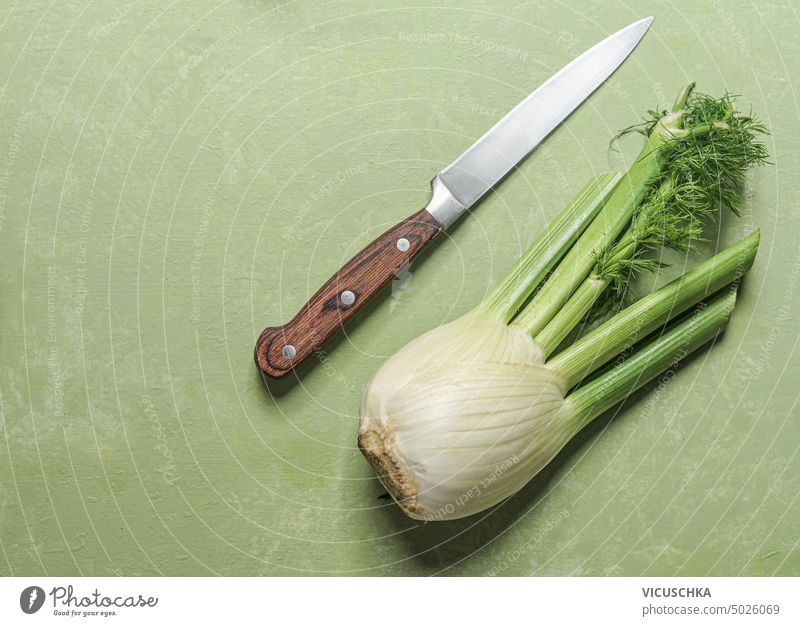 Fenchel mit Messer auf grünem Hintergrund, Ansicht von oben Draufsicht Fenchelwurzel Zutaten Essen zubereiten Vegetarier organisch Lebensmittel Gesundheit