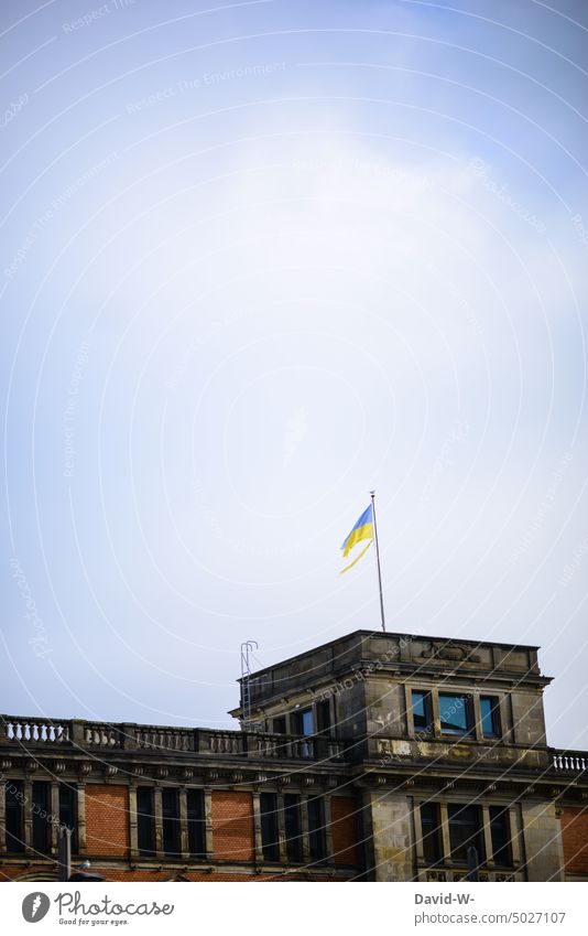 Zerrissene Ukrainische Flagge auf einem Gebäude Ukraine Zerstörung zerrissen Fahne kaputt Krieg Zeichen Symbol ukrainische Flagge Ukraine-Krieg