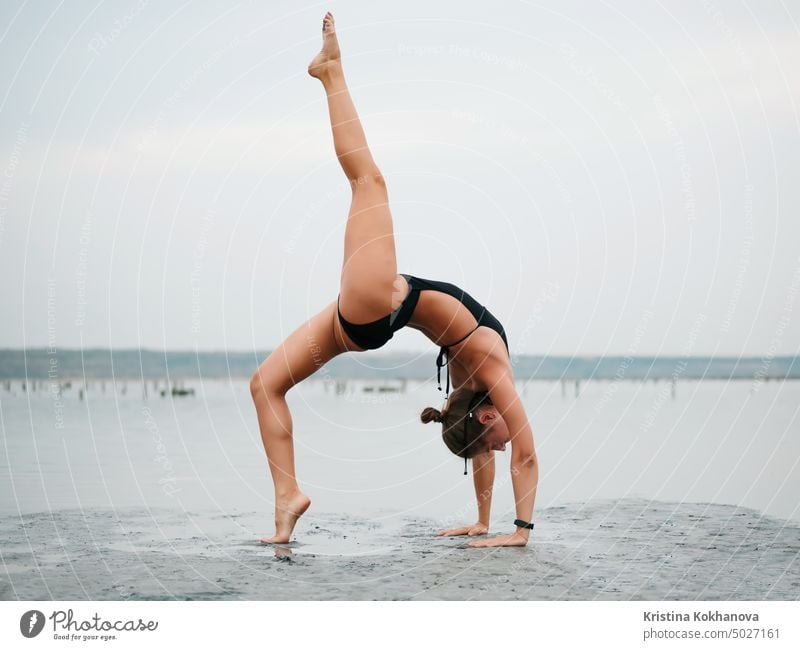 Junge Frau übt Yoga in einer Flussmündung, einem See oder Fluss. Asana, Gleichgewicht. Fitness, Sport. gesunder Lebensstil Konzept. Erwachsener Strand schön