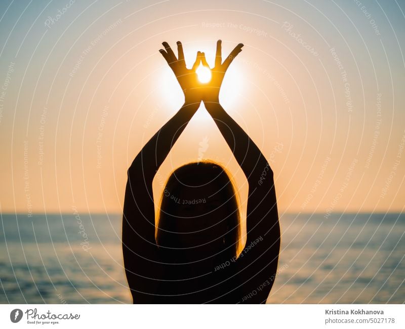 Die Hände einer Frau symbolisieren Gebet und Dankbarkeit. Mudra. Yoga-Konzept. Silhouette der weiblichen Hände auf Sonne Hintergrund. Schöne Szene Fitness