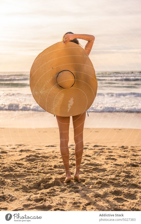 Anonyme Frau mit Strohhut am Strand stehend Sommer MEER Meeresufer Tierhaut Deckung Urlaub