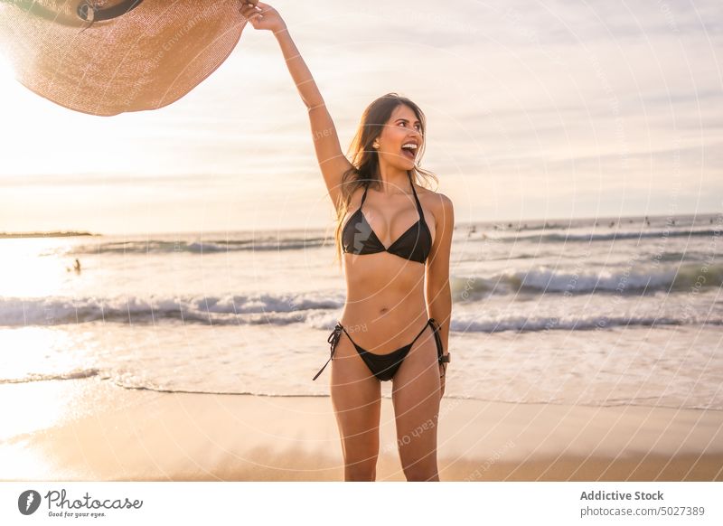 Frau im Bikini und mit Strohhut genießt den Sommer am Strand MEER Urlaub Feiertag genießen c