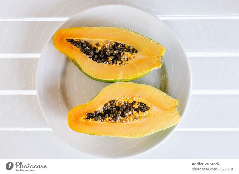 Reife, halbierte Papaya auf einem weißen Keramikteller Frucht exotisch tropisch Vitamin Lebensmittel Teller frisch gesunde Ernährung süß Samen reif