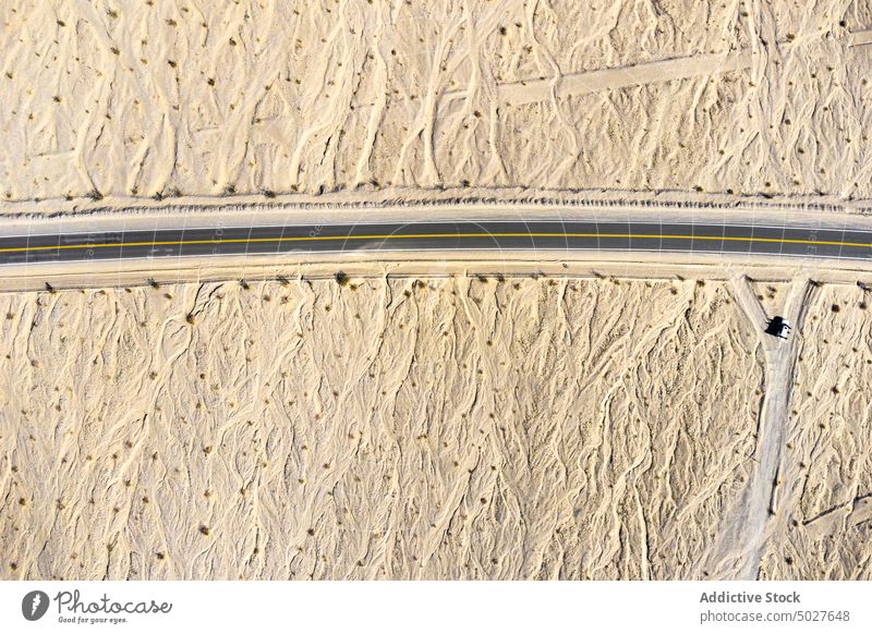 Drohnenansicht einer asphaltierten Straße, die durch ein sandiges Tal in Kalifornien führt Autobahn Berge u. Gebirge Tal des Todes Landschaft Fahrbahn