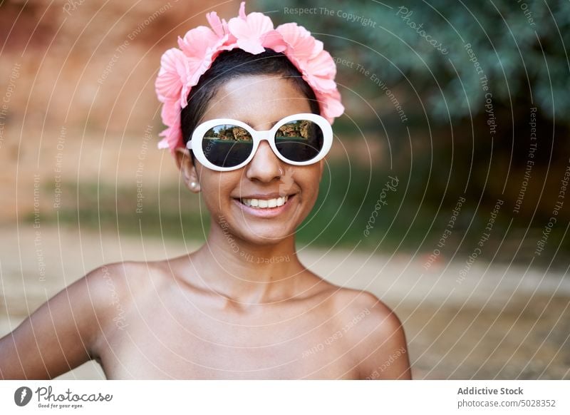 Fröhliche hispanische Touristin mit Sonnenbrille und Kranz Frau Lächeln Stil Sommer Strand Wochenende Urlaub Totenkranz Porträt jung ethnisch Glück Accessoire