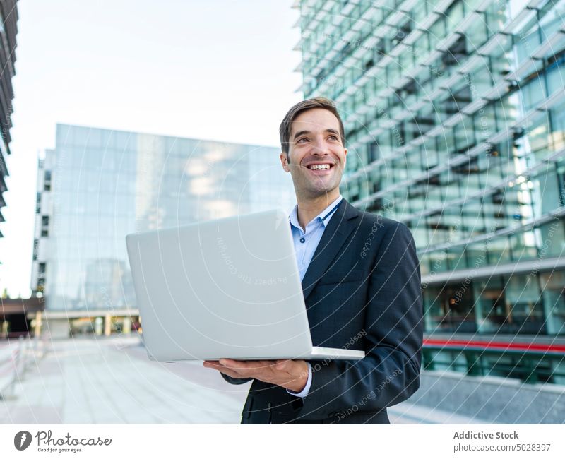 Geschäftsmann beim Surfen mit Netbook in der Nähe eines modernen Gebäudes Unternehmer Laptop benutzend Arbeit Business Browsen Exekutive Mann Computer
