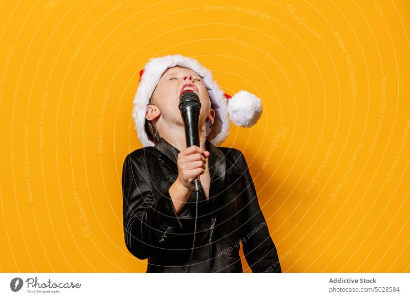 Junge singt lautes Weihnachtslied singen Gesang Weihnachten Mikrofon feiern Feiertag farbenfroh hell Kind schreien Sänger Augen geschlossen Stimme pulsierend