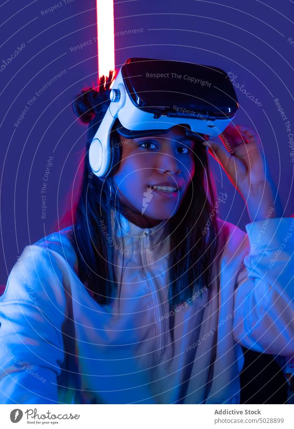 Frau mit VR-Brille vor Neonlicht Virtuelle Realität Headset Schutzbrille eintauchen futuristisch Technik & Technologie interagieren leuchten glühen neonfarbig