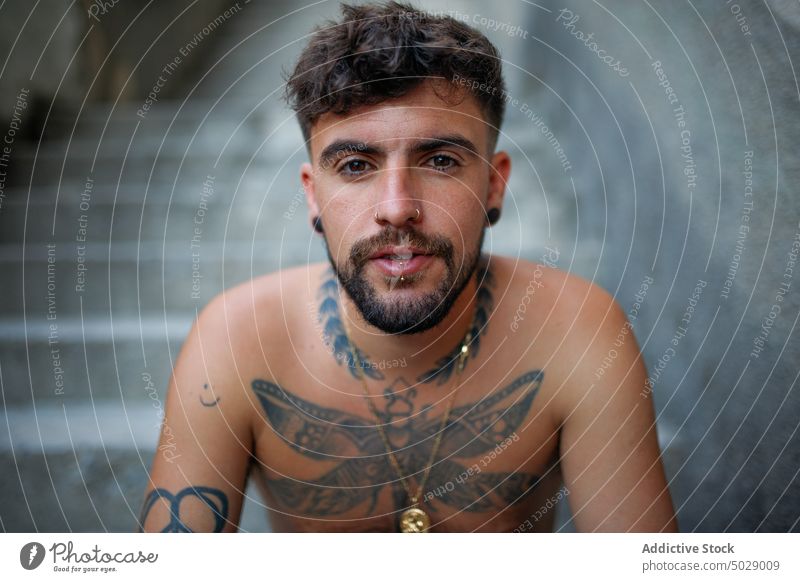 Nachdenklicher junger Mann ohne Hemd mit tätowiertem Körper Tattoo ernst Schritt Vollbart Hipster cool Model besinnlich nachdenklich nachdenken modern