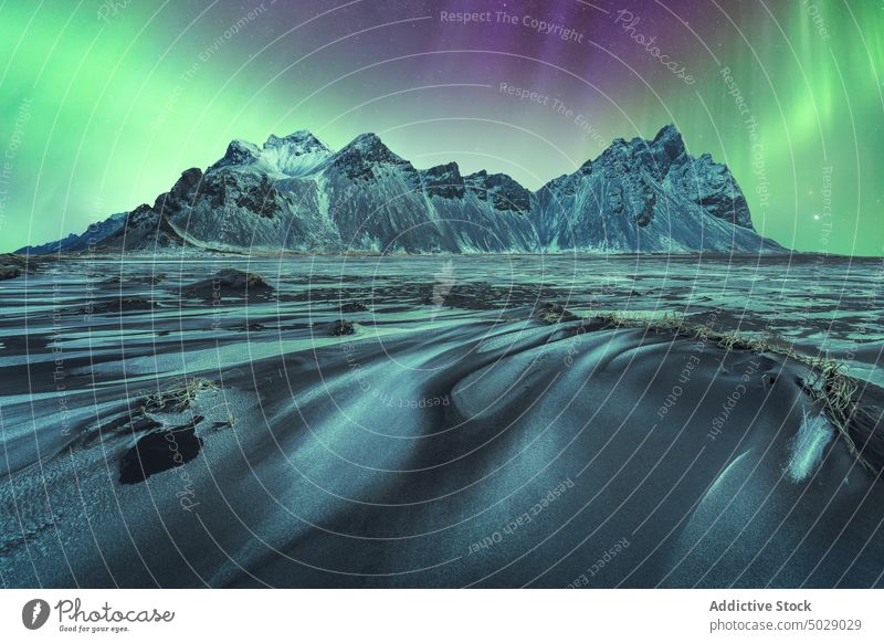 Aussicht auf verschneite Berge und einen See unter einem Himmel mit Polarlicht Nordlicht gefroren Berge u. Gebirge nördlich polar Licht Nacht Winter Kamm Aurora