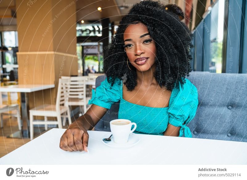 Schwarze Frau mit Kaffee in der Cafeteria Café Kantine Tisch Kälte Kaffeehaus Heißgetränk Restaurant Inhalt trinken Make-up Getränk charmant sitzen schwarz