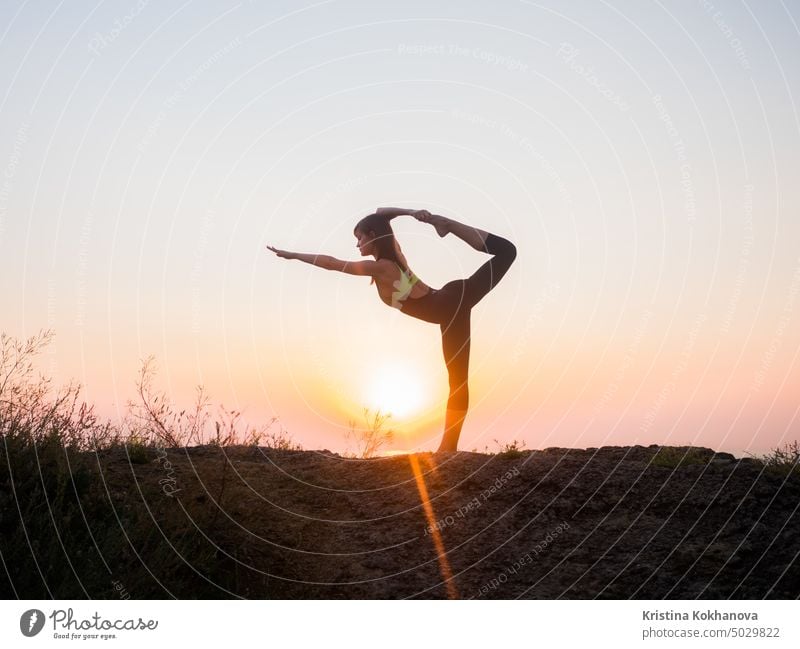 Silhouette junge Frau übt Yoga am Strand über dem Meer auf erstaunliche Sonnenuntergang. Fitness, Sport, Yoga und gesunden Lebensstil Konzept Natur