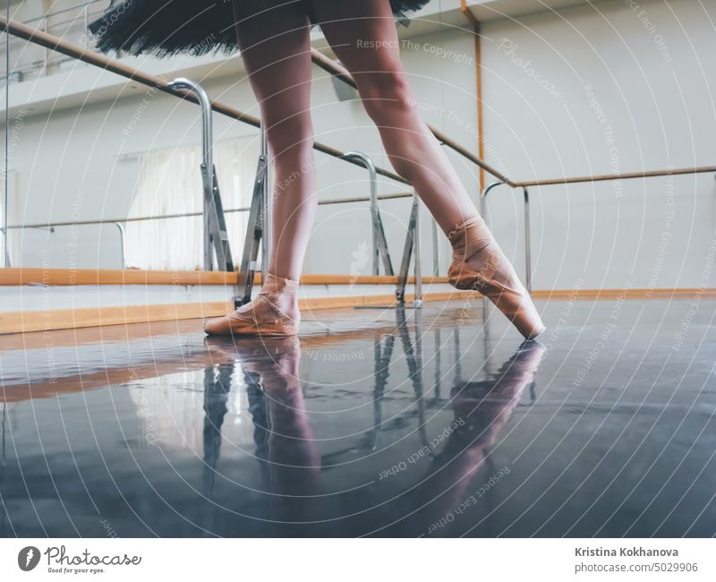 Ballerina in Ballettspitzen dehnt sich an der Stange im Fitnessstudio. Frau übt im Tanzstudio. Work out von jungem Mädchen. Kunst Gleichgewicht Balletttänzer