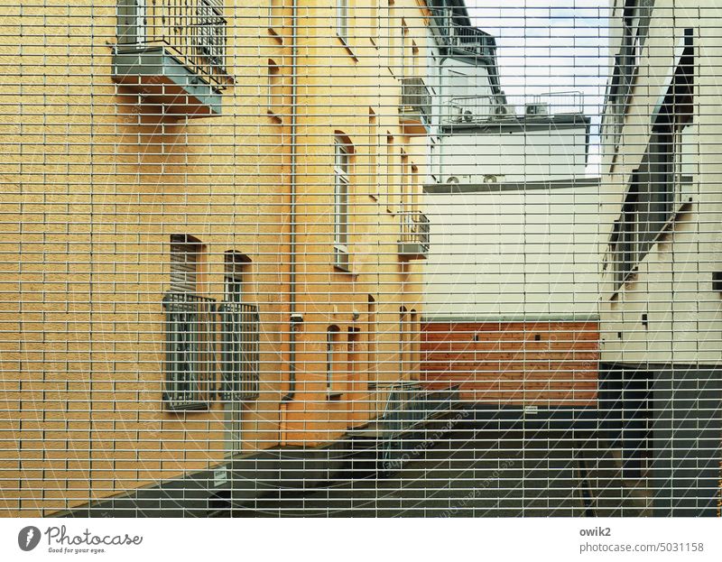 Auf Nummer Sicher Haus Mauer Außenaufnahme Detailaufnahme Metallzaun Gitter Zaun Schutz Begrenzung abweisend geschlossen eng hoch Sicherheit Wand Farbfoto